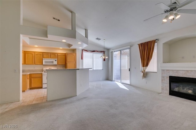 unfurnished living room featuring visible vents, light colored carpet, lofted ceiling, a fireplace, and recessed lighting