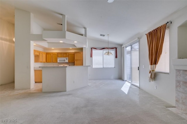 kitchen featuring lofted ceiling, recessed lighting, visible vents, white microwave, and light carpet