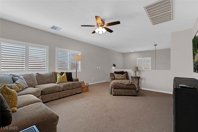 carpeted living room with baseboards, visible vents, and a ceiling fan