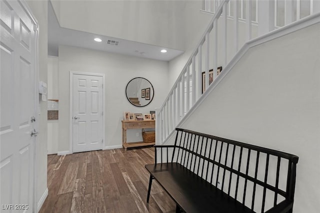 foyer entrance featuring baseboards, visible vents, stairway, wood finished floors, and recessed lighting