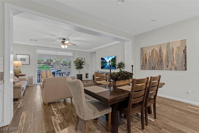 dining space with ornamental molding, wood finished floors, visible vents, and baseboards