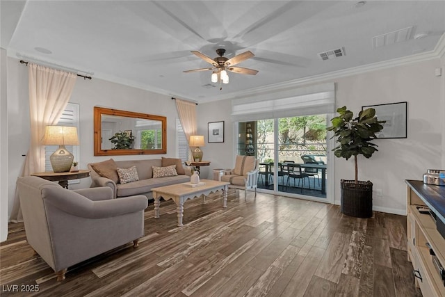 living area featuring ceiling fan, dark wood-type flooring, visible vents, and crown molding