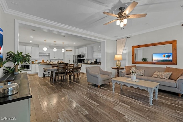 living room with dark wood-type flooring, recessed lighting, a ceiling fan, and crown molding