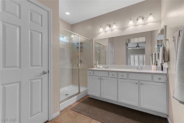 bathroom with double vanity, a stall shower, and a sink