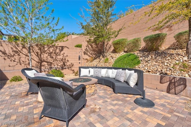 view of patio / terrace with a fenced backyard and an outdoor living space with a fire pit