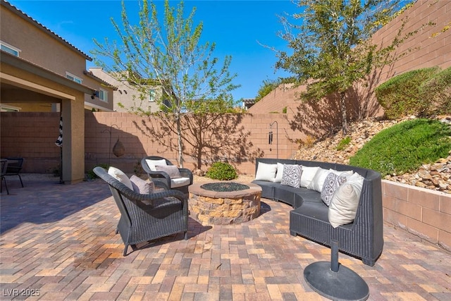 view of patio / terrace with a fenced backyard and an outdoor living space with a fire pit