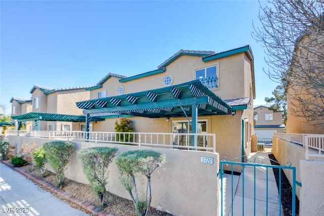 view of front facade featuring a gate, fence, and stucco siding