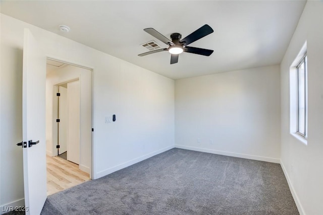 empty room with baseboards, visible vents, ceiling fan, and carpet flooring