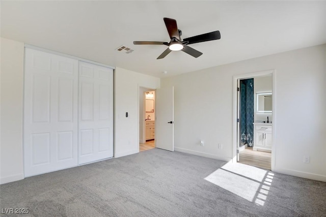 unfurnished bedroom with carpet, a closet, visible vents, and baseboards