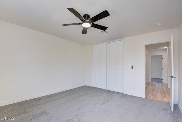 unfurnished bedroom featuring a ceiling fan, a closet, carpet flooring, and baseboards