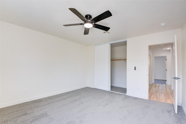 unfurnished bedroom with baseboards, visible vents, ceiling fan, carpet flooring, and a closet