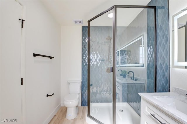 full bathroom with a stall shower, visible vents, wood finished floors, and vanity