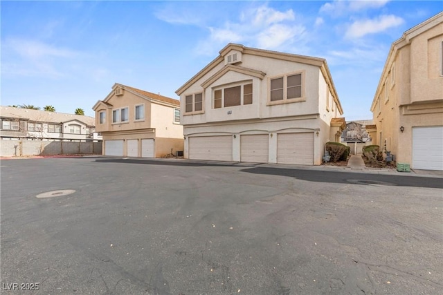 view of front of house featuring a garage, a residential view, and stucco siding