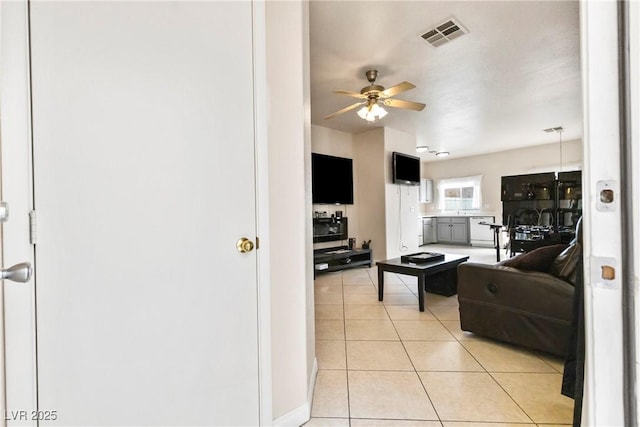 living room featuring light tile patterned floors, visible vents, and a ceiling fan