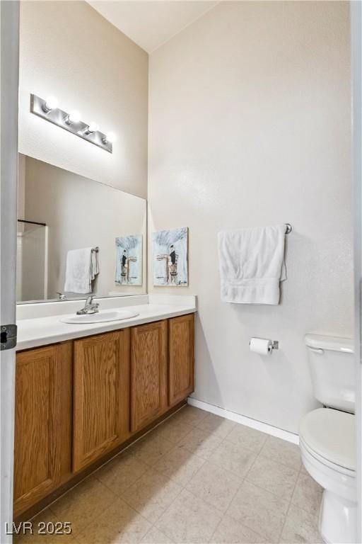 bathroom featuring vanity, toilet, and baseboards