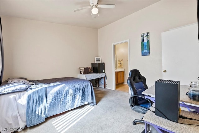 bedroom featuring light carpet, ceiling fan, and ensuite bath