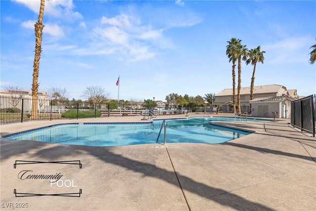 community pool with a patio area and fence