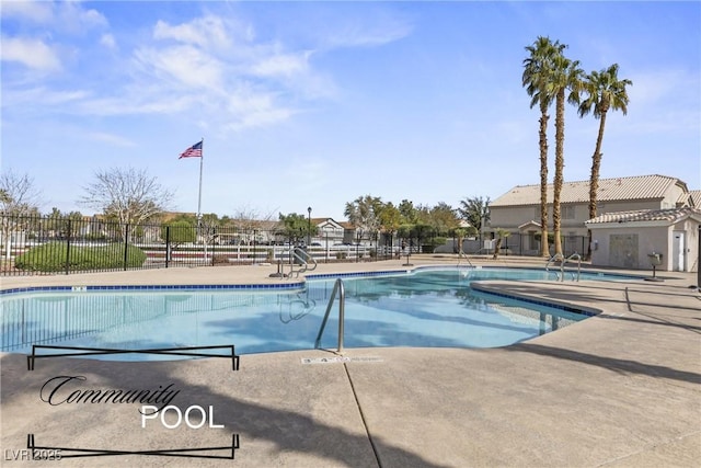 pool with a patio area and fence