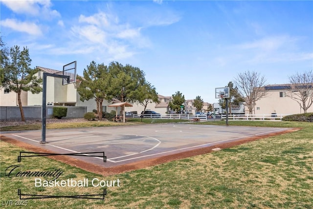 view of basketball court featuring community basketball court, fence, and a lawn