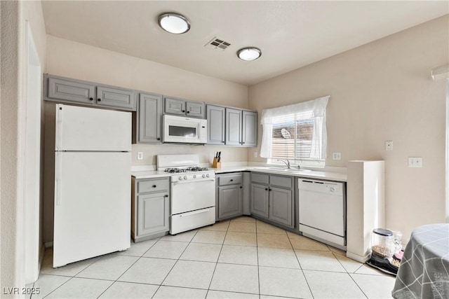 kitchen featuring light tile patterned floors, white appliances, visible vents, light countertops, and gray cabinets