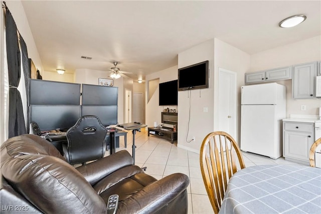 living room with light tile patterned floors, ceiling fan, and visible vents