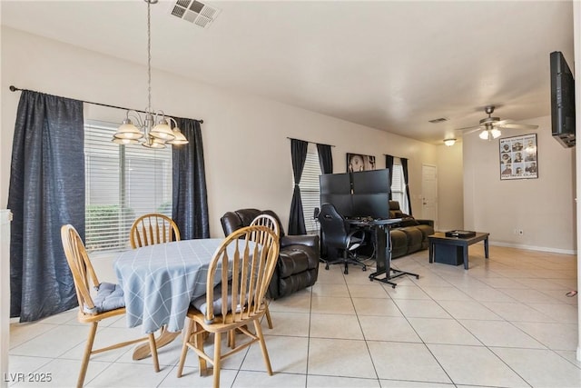 dining space with light tile patterned floors, baseboards, visible vents, and ceiling fan with notable chandelier