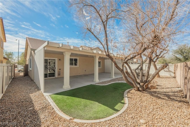 rear view of property featuring a fenced backyard, a patio, and stucco siding