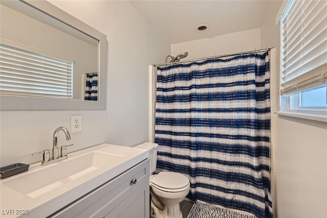 full bath featuring toilet, a shower with shower curtain, and vanity