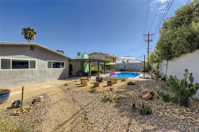 exterior space featuring a fenced in pool, a patio area, a fenced backyard, and stucco siding