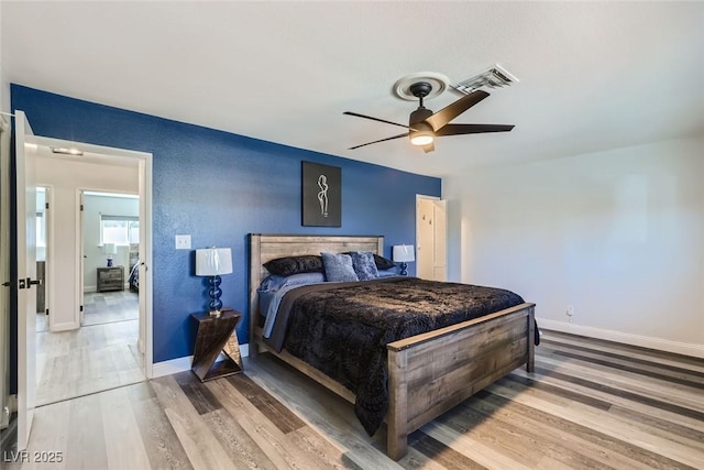 bedroom with light wood finished floors, baseboards, visible vents, and ceiling fan