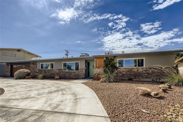 ranch-style home with driveway, brick siding, and an attached garage