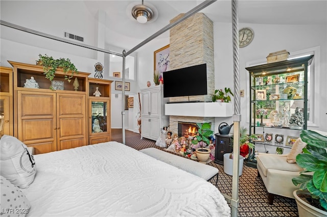 bedroom with high vaulted ceiling, visible vents, and a fireplace