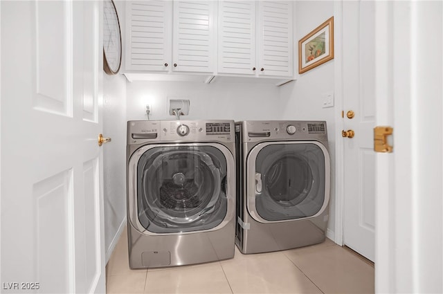 clothes washing area featuring cabinet space, washer and clothes dryer, and tile patterned floors