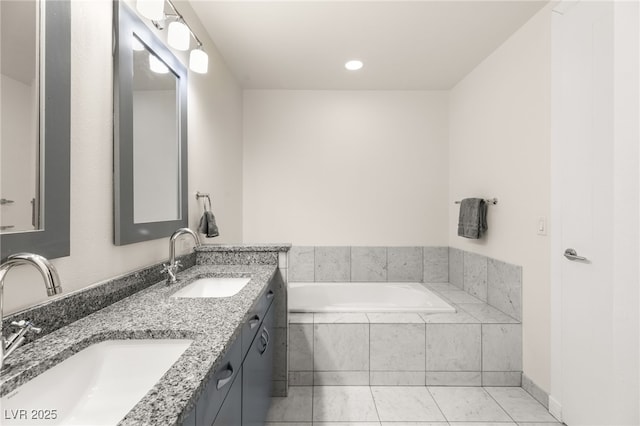 bathroom with tiled bath, tile patterned flooring, a sink, and double vanity