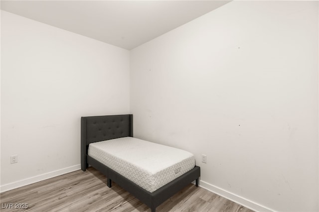 bedroom with baseboards and wood finished floors