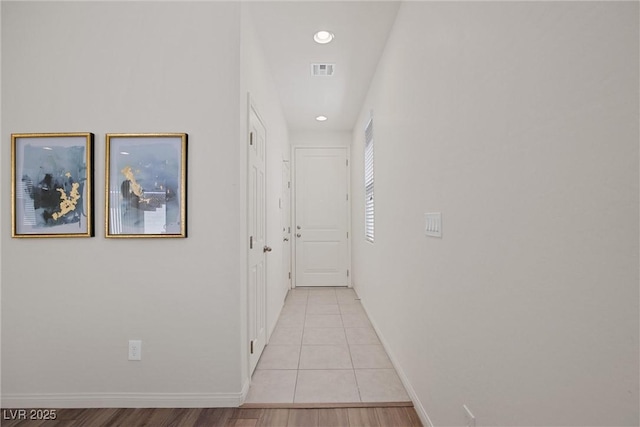 corridor featuring light wood-type flooring, recessed lighting, visible vents, and baseboards