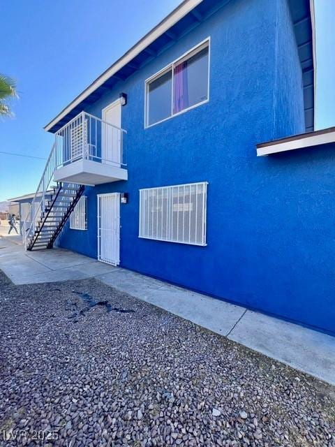 view of home's exterior featuring stairway and stucco siding