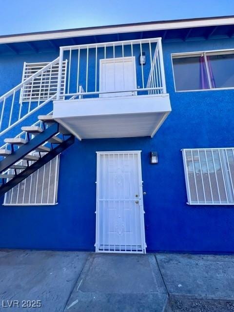 view of exterior entry with a balcony