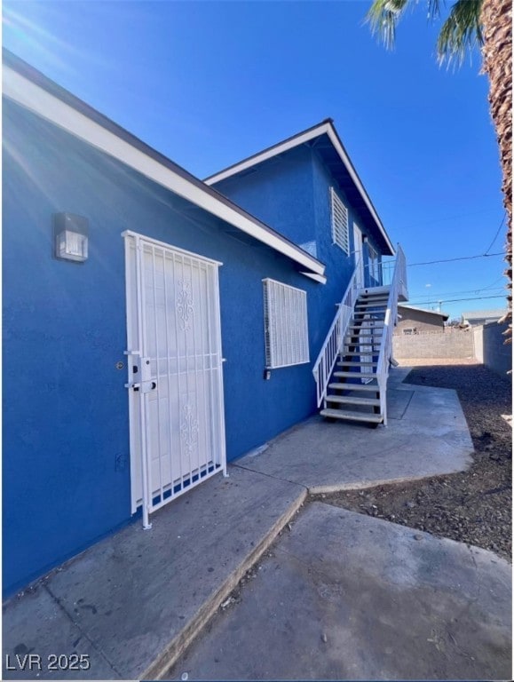 exterior space with fence, a patio, and stucco siding