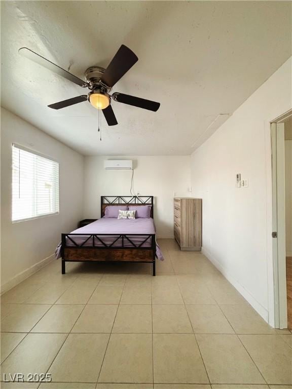 bedroom with ceiling fan, a wall mounted AC, light tile patterned flooring, and baseboards