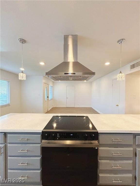 kitchen featuring visible vents, range with electric cooktop, ventilation hood, light countertops, and gray cabinetry