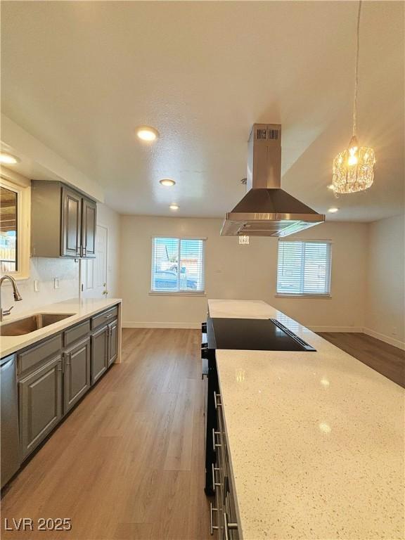 kitchen featuring electric stove, island exhaust hood, light wood finished floors, and a sink