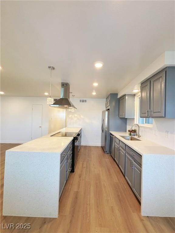 kitchen featuring light countertops, gray cabinetry, appliances with stainless steel finishes, a sink, and extractor fan