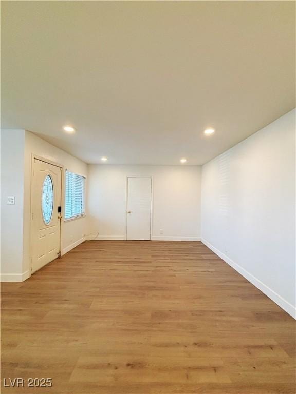 interior space featuring light wood-type flooring, baseboards, and recessed lighting