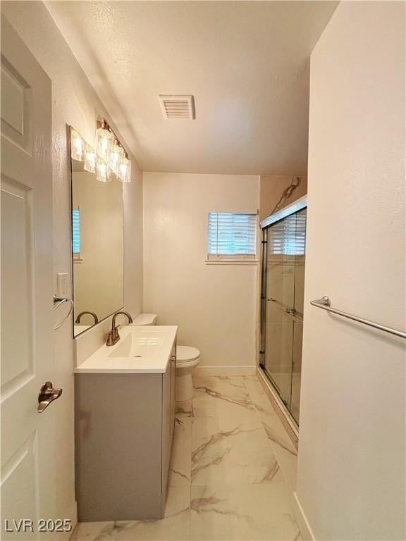 full bathroom featuring toilet, vanity, visible vents, marble finish floor, and a stall shower