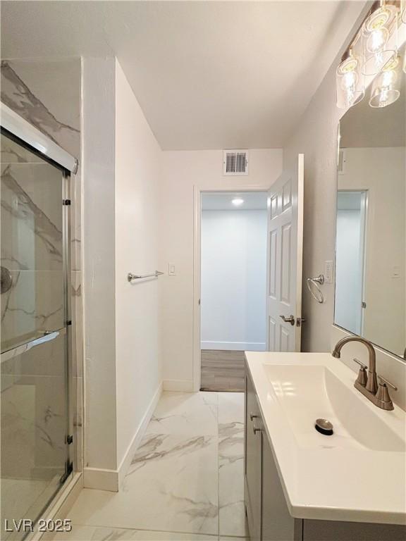 full bath featuring marble finish floor, a marble finish shower, visible vents, and baseboards