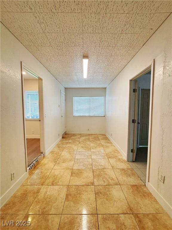 unfurnished room with baseboards and light tile patterned floors