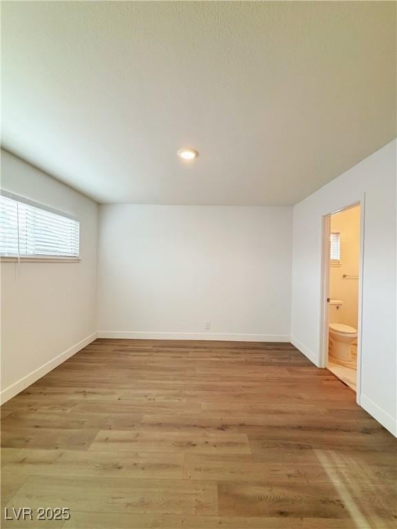 unfurnished room featuring recessed lighting, light wood-type flooring, and baseboards