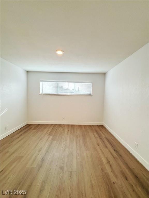 unfurnished room featuring baseboards, light wood finished floors, and a healthy amount of sunlight