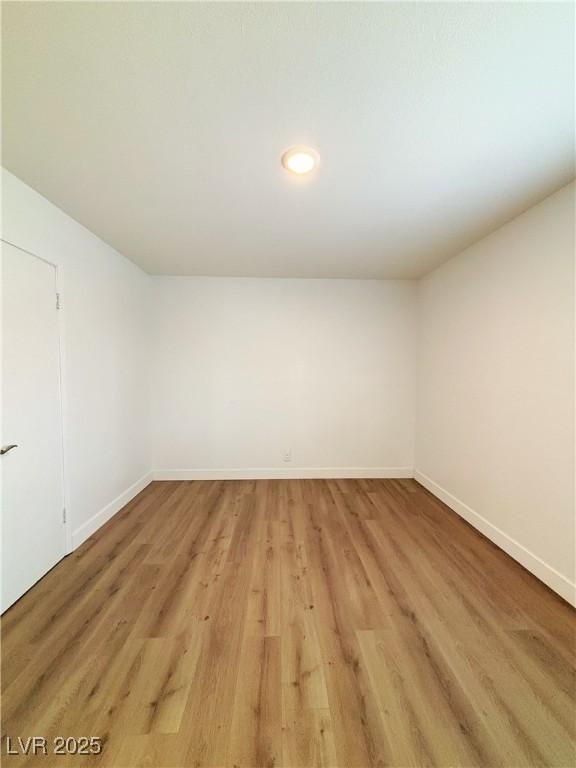 empty room with light wood finished floors and baseboards